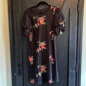 Black boutique dress with embroidered flowers.